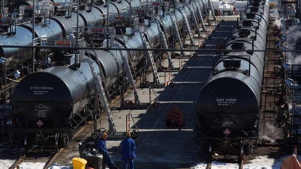 Irving Oil workers inspect rail cars carrying crude oil at the Irving Oil rail yard terminal