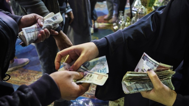 <p>A customer pays for a purchase with Egyptian pound banknotes at a market in Cairo, Egypt.</p>
