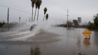 <p>A vehicle drives through a flooded street during a storm in Whittier, California.</p>