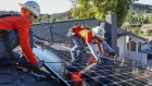 Workers install solar panels on the rooftop of a home in Poway, California. Photographer: Sandy Huffaker/Bloomberg