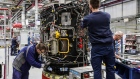 <p>Employees work on a jet engine.</p>