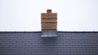 <p>The chimney stack and roof tiles of a new home.</p>