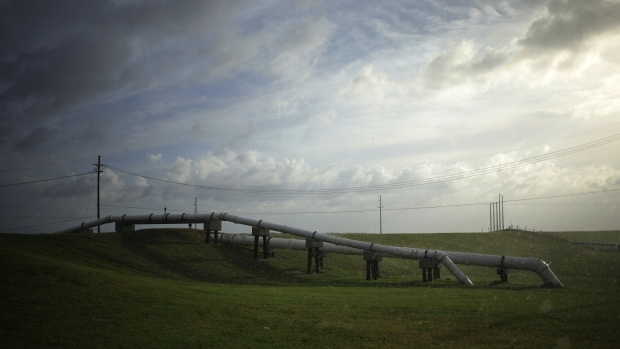 A pipeline runs across a levee ahead of Hurricane Ida in Golden Meadow, Louisiana, U.S., on Saturday, Aug. 28, 2021. Hurricane Ida is growing in size and power as it moves north across the Gulf of Mexico toward Louisiana, and New Orleans is bracing for disaster -- clearing out hospital wards, shutting down oil refineries and forcing residents of low-lying neighborhoods to flee.