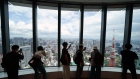 Members of the media look out from the 52nd floor of the Azabudai Hills Mori JP Tower in Tokyo, Japan, on Tuesday, Aug. 8, 2023. Azabudai Hills, the latest large-scale real estate project by Mori Building Co., will open for business on Nov. 24, seeking to boost Tokyo’s attractiveness as an international destination. Photographer: Toru Hanai/Bloomberg