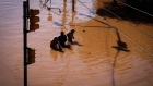 Residents walk through floodwater in Porto Alegre on May 6. Photographer: Carlos Macedo/Bloomberg