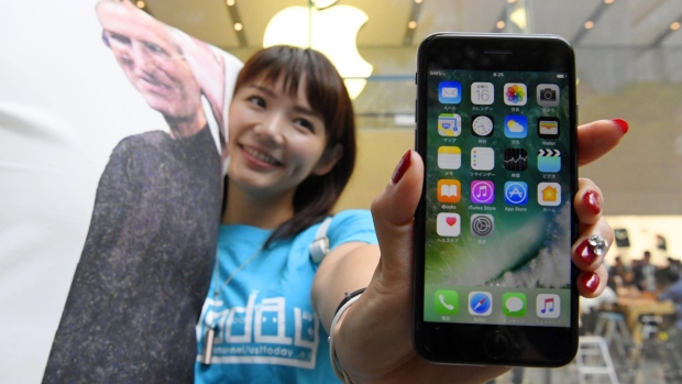 A woman poses with Apple's iPhone 7 after purchasing it in Tokyo