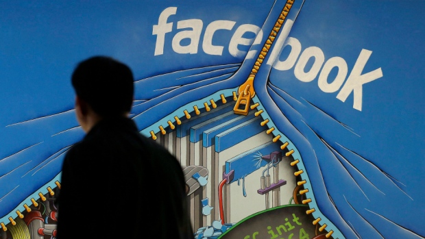 A man walks past a mural in an office on the Facebook campus in Menlo Park, California.
