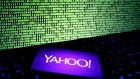 A photo illustration shows a Yahoo logo on a smartphone in front of a displayed cyber code