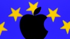 A 3D printed Apple logo is seen in front of a displayed European Union flag