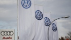 A logo of Audi is pictured next to flags with logos of VW at a car shop in Germany