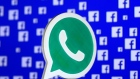 A 3D printed Whatsapp logo is seen in front of Facebook's logo