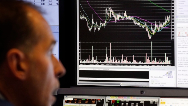 A stock trader follows stock information on electronic screens at the New York Stock Exchange
