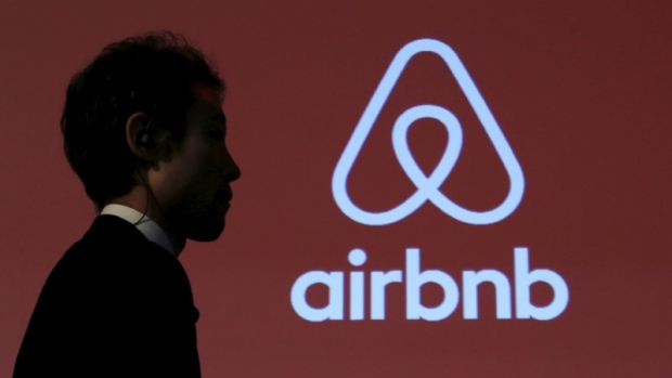 A man walks past a logo of Airbnb after a news conference in Tokyo, Japan, November 26, 2015. 