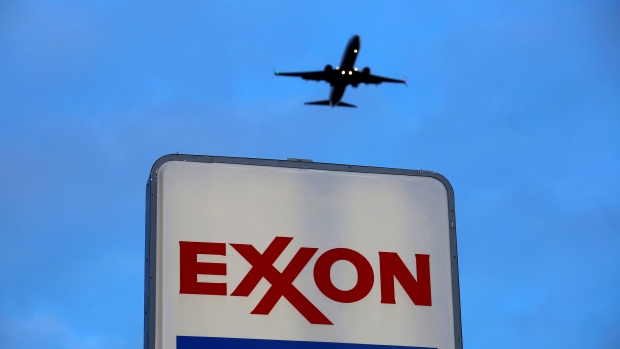 An airplane comes in for a landing above an Exxon sign at a gas station in Norridge, Illinois