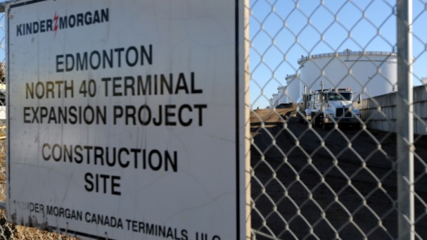 Dump trucks are parked near crude oil tanks at Kinder Morgan's North 40 terminal expansion construction project in Sherwood Park