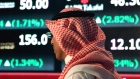 A Saudi man walks at the Tadawul Saudi Stock Exchange, in Riyadh, Saudi Arabia