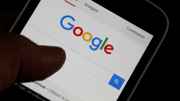 A man holds his smartphone which displays the Google home page in this picture illustration