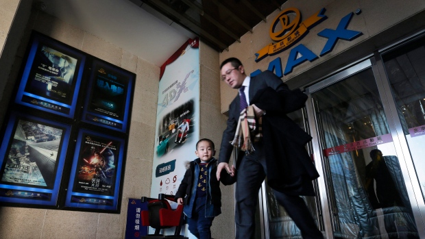 , a man and his son walk out from the Wanda Cinema at the Wanda Group building in Beijing. 