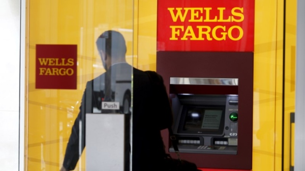 A man walks by a bank machine at the Wells Fargo & Co. bank in downtown Denver, Colorado