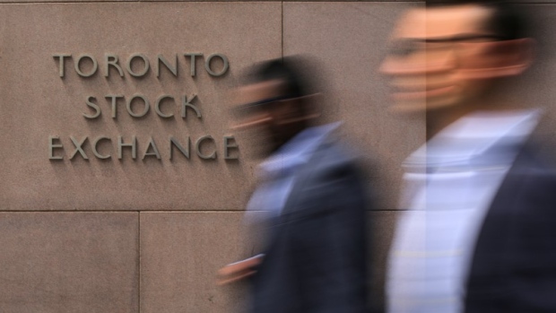 Businessmen pass the Toronto Stock Exchange sing in Toronto