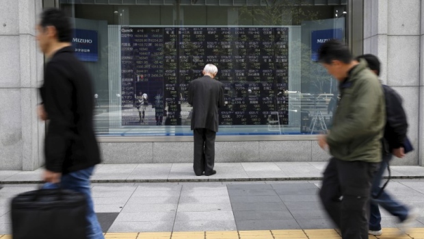 A man looks at a stock quotation board outside a brokerage in Tokyo, Japan, April 18, 2016. 
