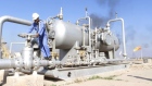 A worker checks the valve of an oil pipe at Nahr Bin Umar oil field, north of Basra, Iraq