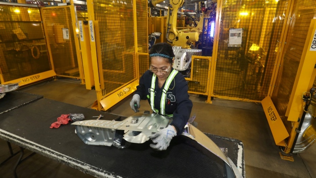Worker checks welded part from auto weld assembly line at Alfield Industries