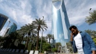 A man speaks on the phone as he walks past the Kingdom Centre Tower in Riyadh, Saudi Arabia