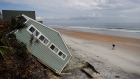 A house rests on the beach after collapsing off a cliff from Hurricane Irma in Vilano Beach, Fla.