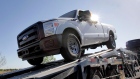 In this March 29, 2011 photo, new 2011 Ford F-250 trucks are delivered to a dealership in Glbert, AZ