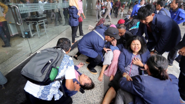 Injured persons are evacuated from the Jakarta Stock Exchange tower in Jakarta, Indonesia.